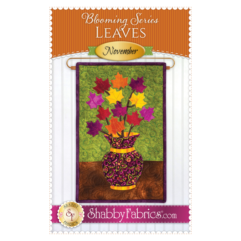 The front of the Blooming Series - November pattern by Shabby Fabrics showing the finished wall hanging with a bouquet of autumn leaves.