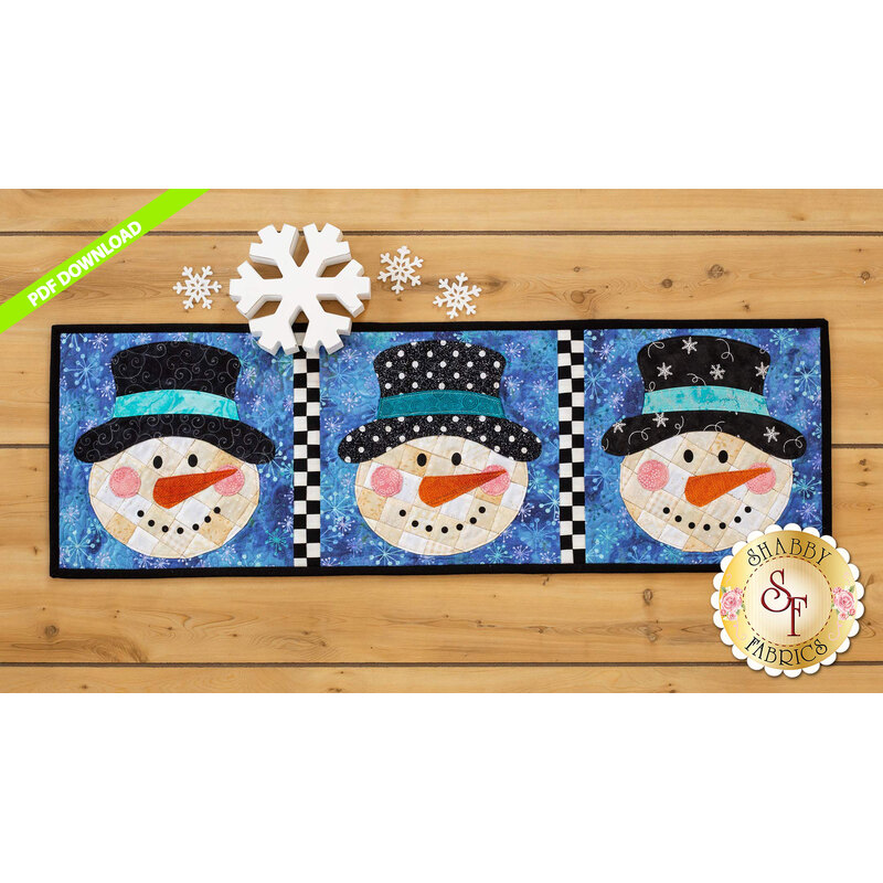 Table runner featuring three smiling snowmen with different hats on a blue backgrounds.