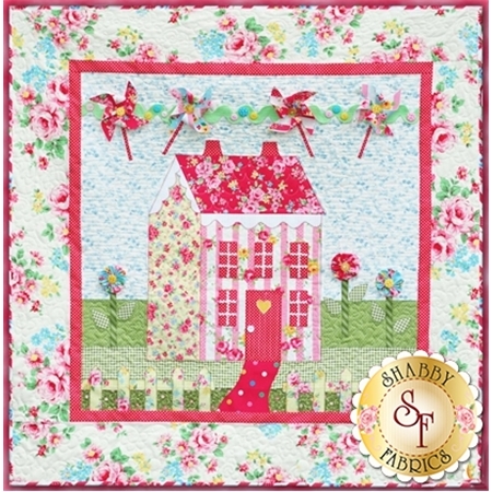 Pink and yellow cottage house with flowers and pinwheels.