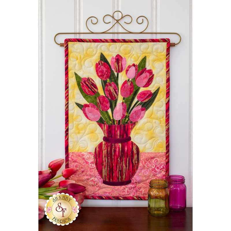 Pink tulips in magenta striped vase.