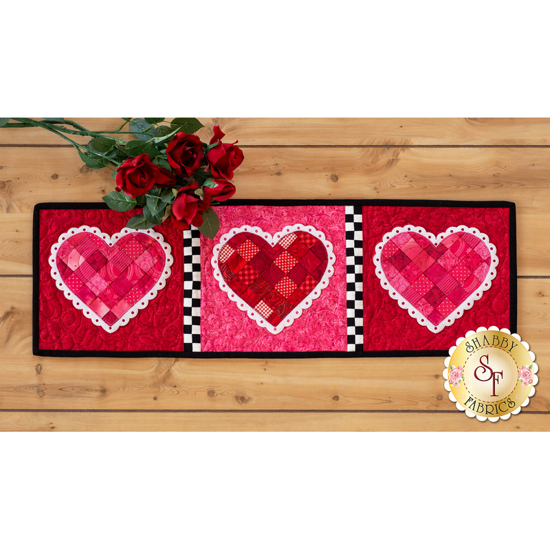 Table runner featuring red and pink patchwork hearts with mock lace applique borders.