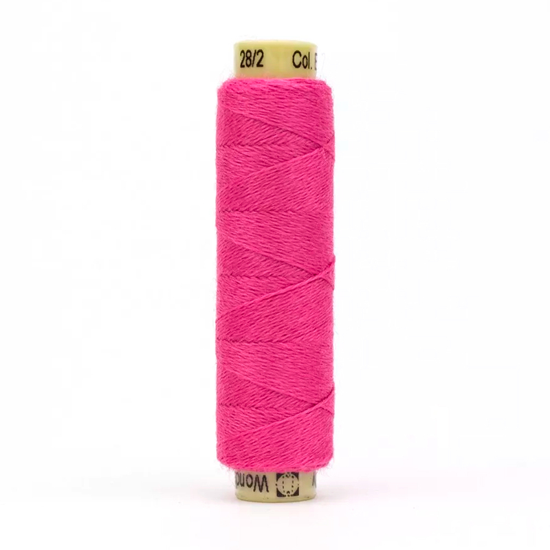 A spool of bright pink EN23 - Flamingo thread on a white background