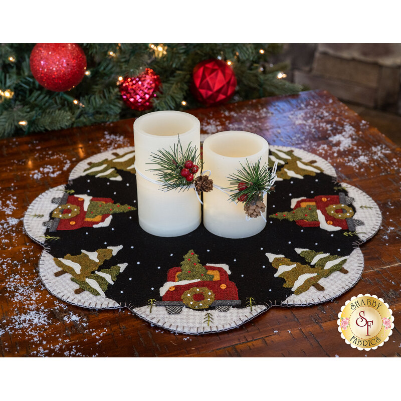 The Hauling The Tree All Around Mat displayed with beautiful Christmas candles
