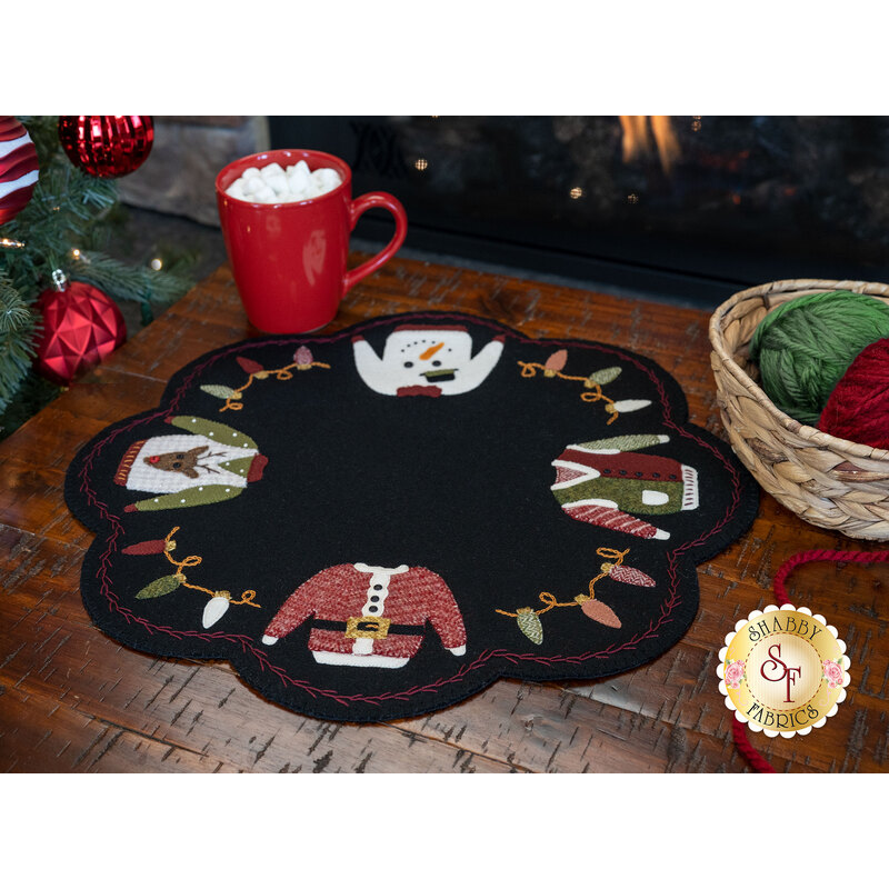 Adorable wool ugly sweater mat displayed on a wood table