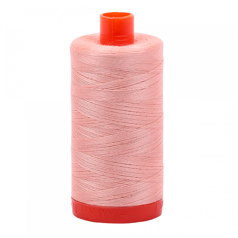 A spool of Aurifil 2420 - Fleshy Pink thread on a white background