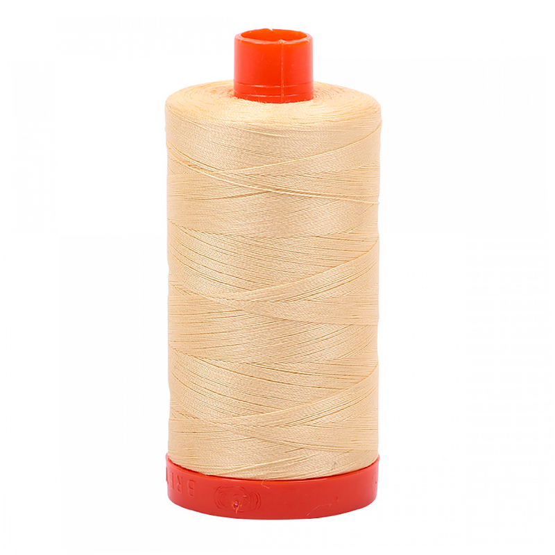 A spool of Aurifil 2105 - Champagne thread on a white background