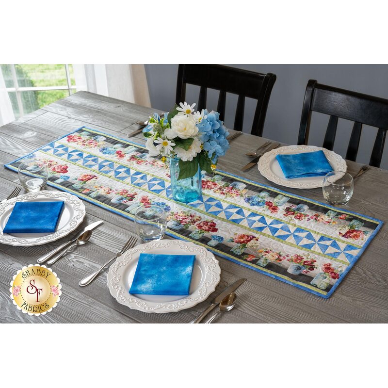 The beautiful Flower Market Pinwheel Stripe Table Runner displayed on a set table | Shabby Fabrics