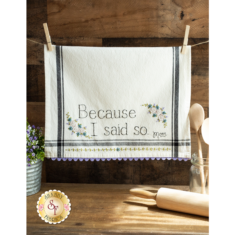 A vintage style dish towel with hand embroidered floral motifs and the words 