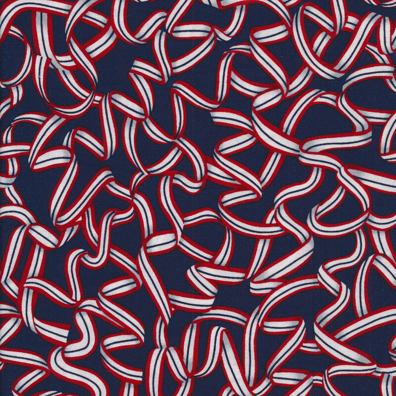 Fabric features red white blue ribbon design strewn on navy blue background | Shabby Fabrics