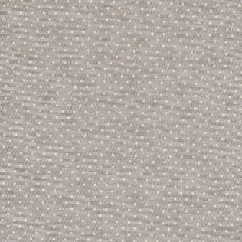 This Moda fabric features a light gray background with off white polka dots