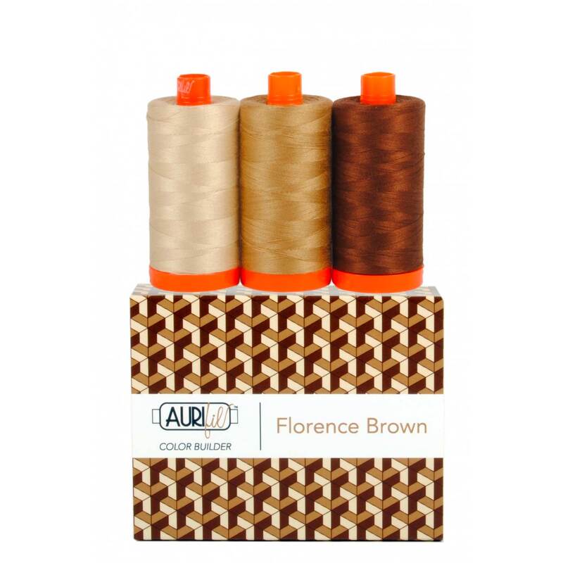 A spool of light tan, medium tan, and dark brown thread on an Aurifil Colorbuilder box