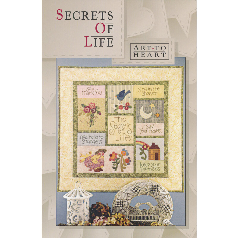 The front of the Secrets of Life pattern by Art to Heart featuring a bouquet of flowers, a house with a rainbow, a flying bluebird, and sweet sayings.