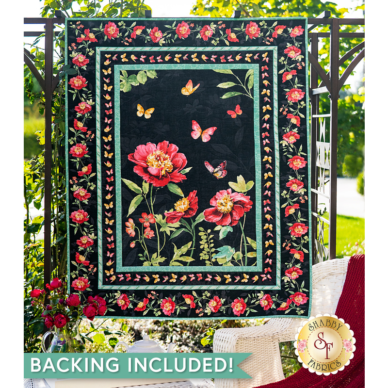 A beautiful black, pink, and teal quilt hanging outdoors